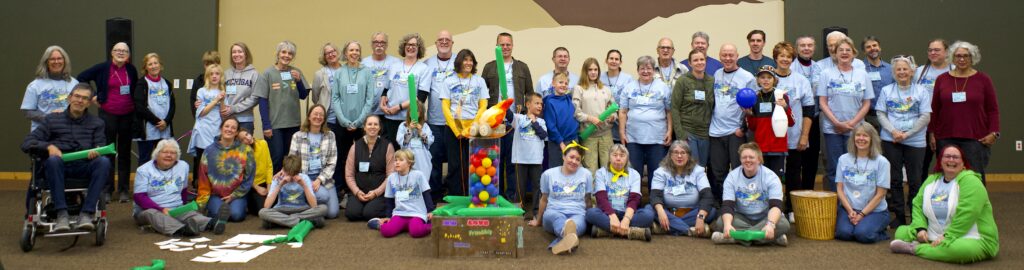 A group photo from our 2025 Fall retreat. Common Flame members pose beside a chalice sculpture that they crafted together as a team.
