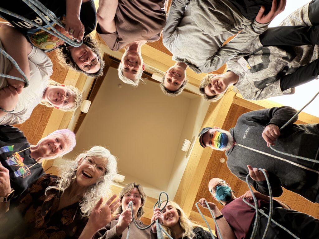 Members of the Queer Connections group stand in a circle for a group photo