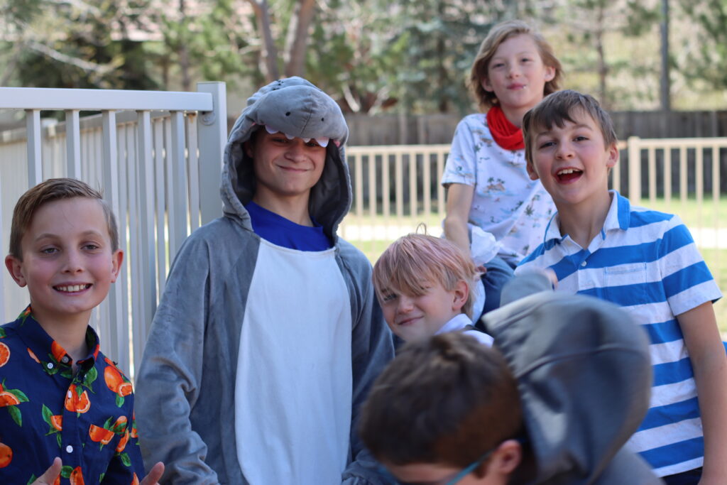 A group of kids and youth pose for a photo while playing outside.